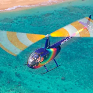 Helicopter flying over lush green landscapes of Oahu