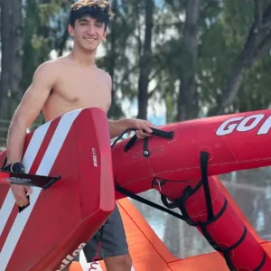 Person riding wing foil board over blue ocean waves