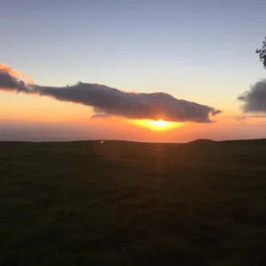 Horseback riders enjoying a colorful sunset on the horizon