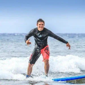 Instructor teaching private surf lesson on clear ocean waves