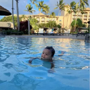 Instructor teaching child how to swim in pool