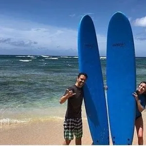 Private surf instructor guiding lesson on tropical island beach