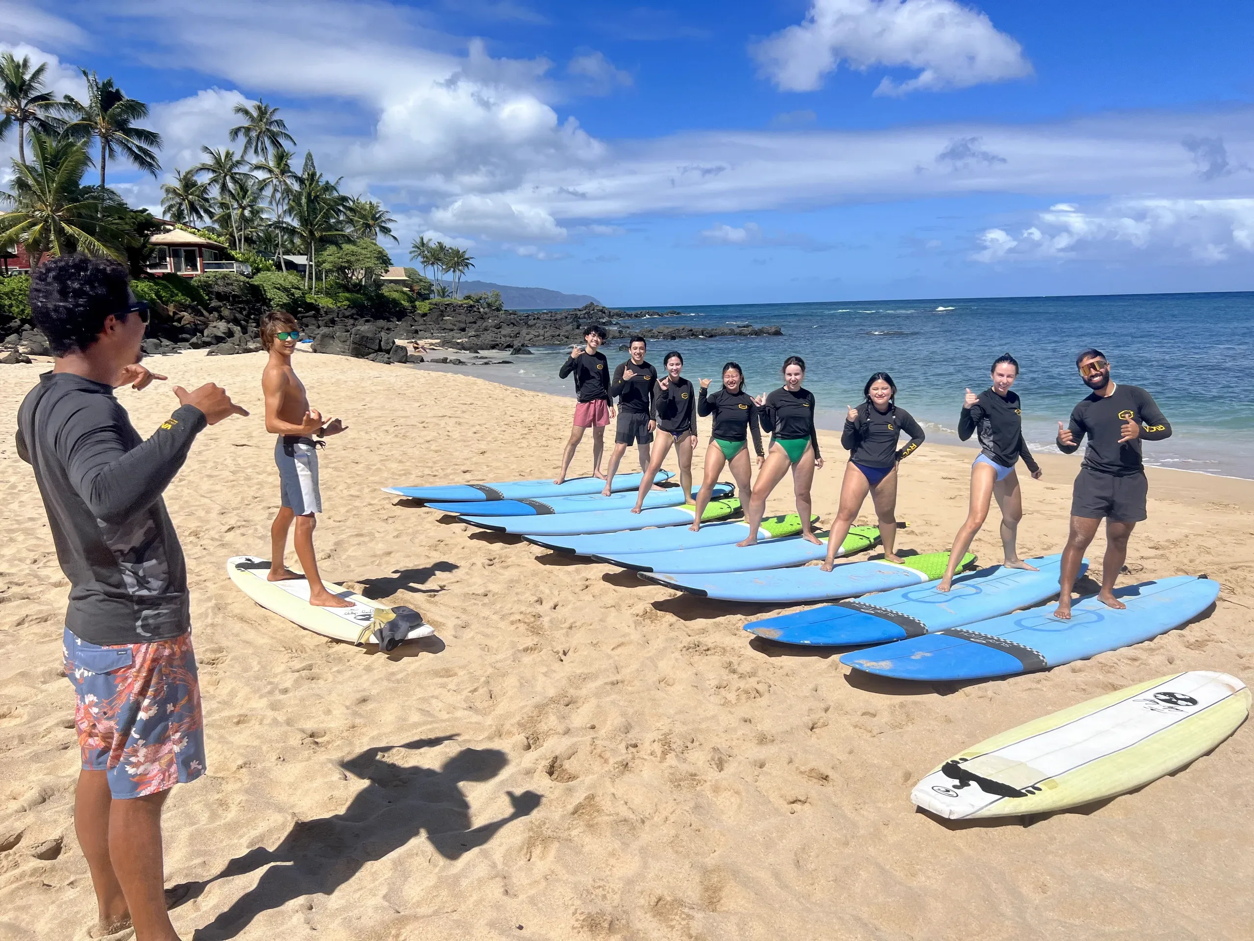 Instructors teaching surf techniques to private group in Hawaii