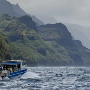 Boat cruising along Nā Pali Coast during winter morning
