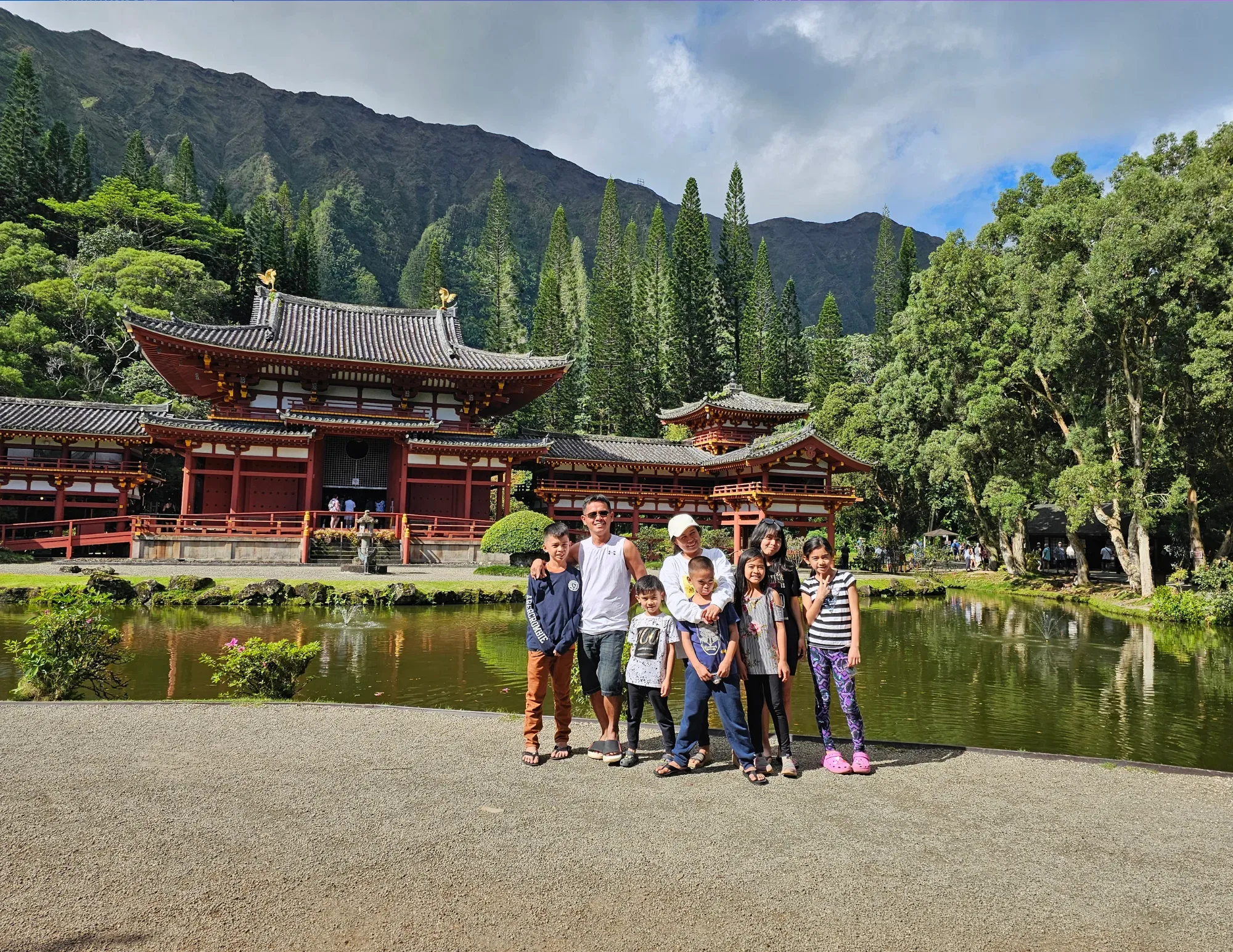 Visitors admiring Byodo-In Temple surrounded by lush Oahu greenery