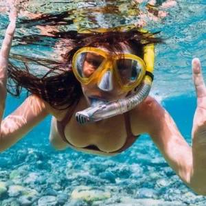 Snorkeler swimming close to sea turtles underwater
