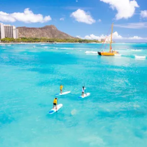 Small group paddleboarding together on calm ocean waters