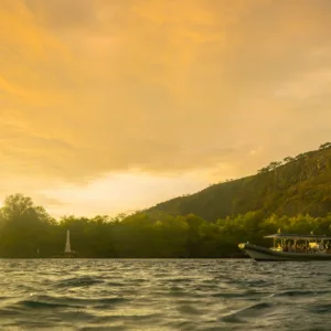Super-raft boat cruising at sunset along Kona coastline