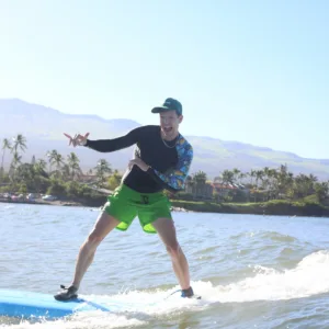 Instructor teaching surfing to beginner in ocean
