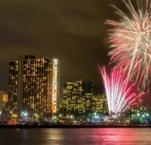 Sailboat cruising under fireworks at night