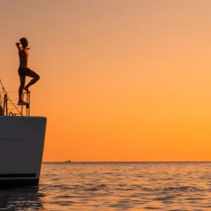 Luxury yacht sailing near Diamond Head at sunset