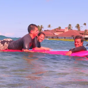 Two people learning to surf on gentle waves