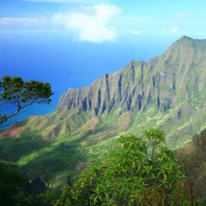 Helicopter flying over rugged Na Pali Coast cliffs