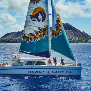 Sailing catamaran cruising near Waikiki coastline and reefs