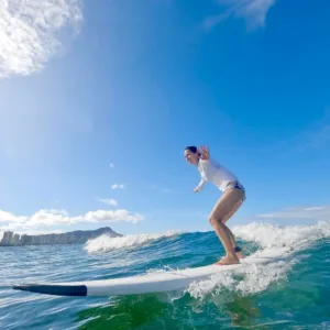 Group of surfers learning to catch waves on sandy beach