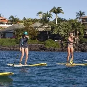 Stand up paddleboarder gliding across calm Hawaiian waters