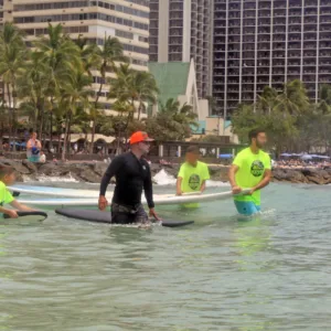 Group of surfers receiving lesson on sandy beach