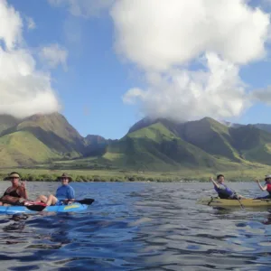 Kayakers paddling near West Maui Mountains