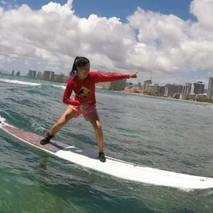 Beginner surfer catching a wave at Waikiki Beach