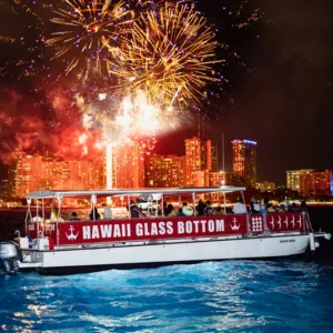 Boat cruising near Honolulu skyline at night