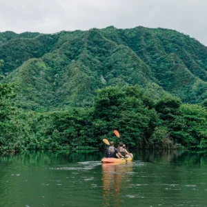 Kayakers preparing for river journey in lush rainforest