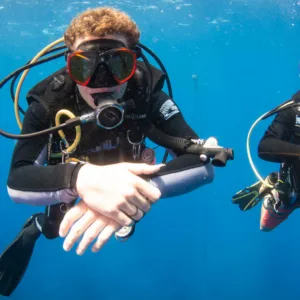 Beginner scuba divers preparing for ocean dive