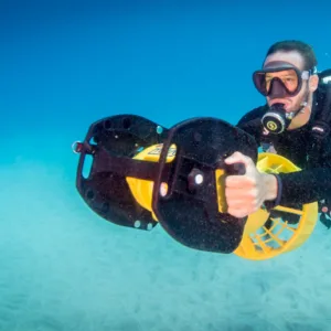 Experienced diver riding underwater scooter