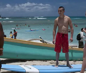 Family enjoying group surf lesson on beach