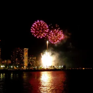 Boat cruising Waikiki coastline during fireworks display