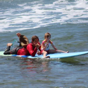 Children learning to surf on calm Oahu beach