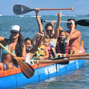 People paddling canoe along scenic coastline