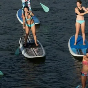 Paddler navigating calm river during SUP lesson